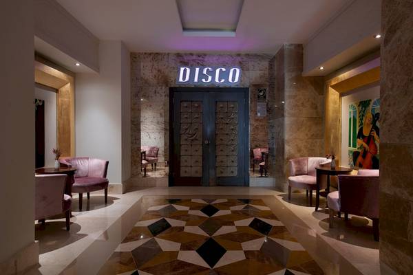Der Disco-Eingang des Sentido Kamelya Selin Hotels mit braunen Türen und einem geometrischen Bodenmuster.