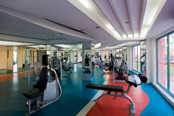 Fitnessstudio im Sentido Kamelya Selin Hotel mit vielen Trainingsgeräten und großen Fenstern
