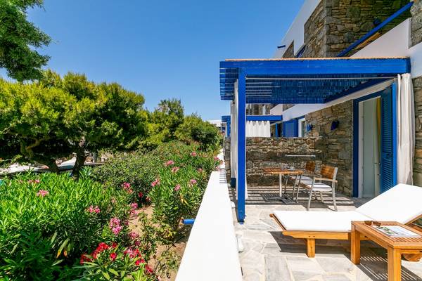 Terrasse des Mykonos Theoxenia Boutique Hotels mit Tisch, Stühlen und Lounges im Freien.