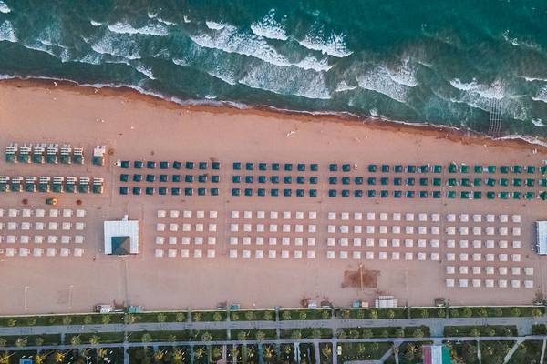 Luftaufnahme des Strandes des Sentido Kamelya Selin Hotels mit vielen Sonnenschirmen und Liegen