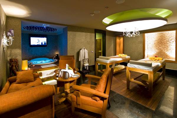 Wellnessbereich im Sentido Kamelya Selin Hotel mit Whirlpool, Betten und Fernseher.