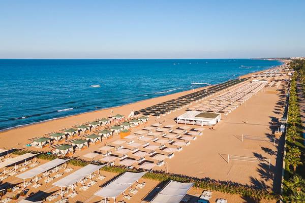 Luftaufnahme der Sandstrand mit vielen Sonnenliegen und Umbrellas im Sentido Kamelya Selin Hotel.