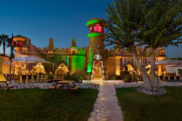 Außenansicht des Sentido Kamelya Selin Hotels bei Nacht mit leuchtenden Gebäuden und Bäumen.