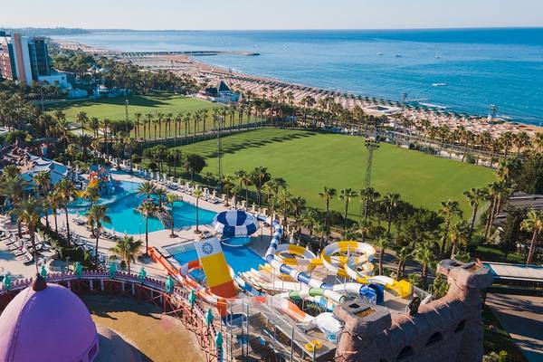 Luftaufnahme des Sentido Kamelya Selin Hotels mit Wasserrutschen, Pools und einem Blick auf das Meer.