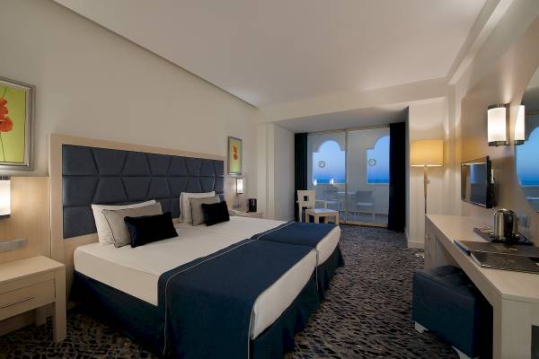 Hotelzimmer im Sentido Kamelya Fulya mit zwei Betten, Dekor und Ausblick auf den Ozean.