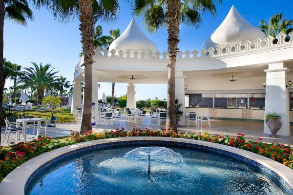 Außenterrasse des Sentido Kamelya Fulya Hotels mit Brunnen, Tischen und Stühlen