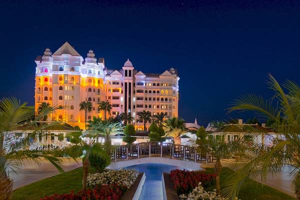 Das Sentido Kamelya Fulya Hotel ist nachts beleuchtet und zeigt seine architektonischen Details.