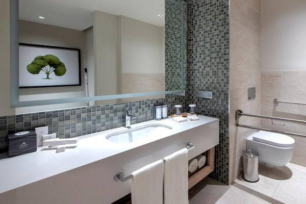 Badezimmer im Lopesan Costa Bavaro Resort Spa & Casino mit großem Spiegel, Waschbecken und Toilette.