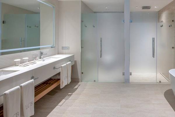 Modernes Badezimmer im Lopesan Costa Bavaro Resort Spa & Casino mit Badewanne, Dusche und Doppelwaschbecken.