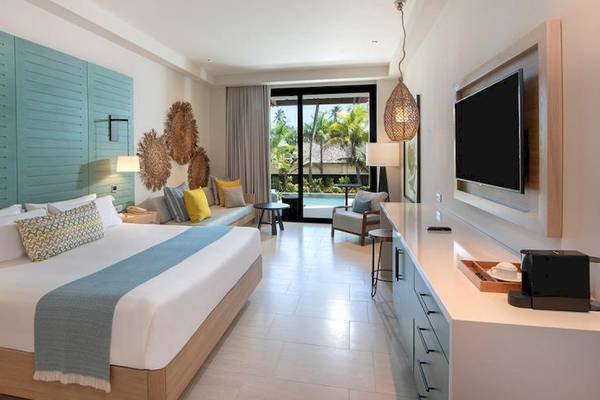 Suite im Lopesan Costa Bavaro Resort Spa & Casino mit Bett, Sofa, Fernseher und Poolblick