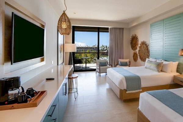 Doppelzimmer im Lopesan Costa Bavaro Resort Spa & Casino mit zwei Betten, Fernseher, Schreibtisch und Balkon.