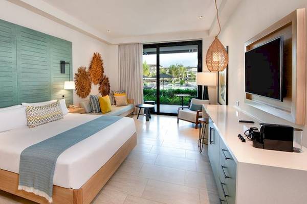 Hotelzimmer im Lopesan Costa Bavaro Resort mit Bett, Fernseher, und Wohnbereich.