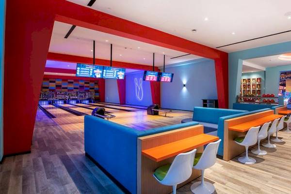 Bowlinghalle im Lopesan Costa Bavaro Resort Spa & Casino mit roten und blauen Wänden und Holzböden.