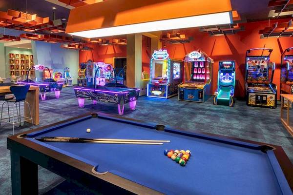 Spielbereich im Lopesan Costa Bavaro Resort mit Billardtisch, Spielautomaten und Sitzgelegenheiten.