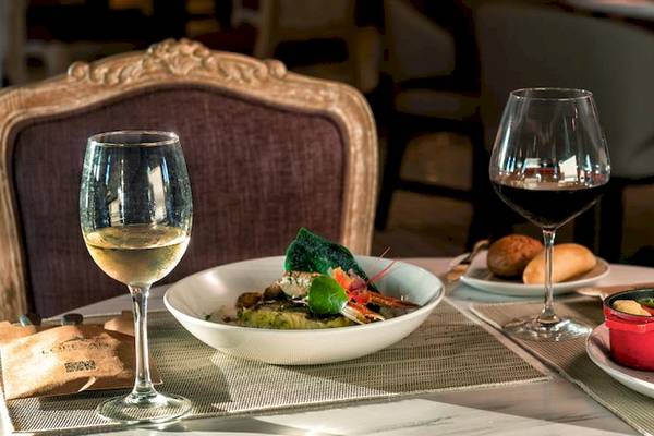 Speisetisch im Lopesan Costa Bavaro Resort Spa & Casino mit Wein, Salat und Steak.