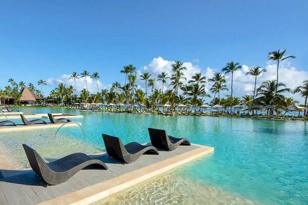 Außenpool des Lopesan Costa Bavaro Resort Spa & Casino mit Liegestühlen und Palmen
