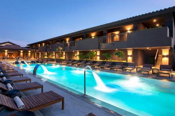 Außenpool des Lopesan Costa Bavaro Resort Spa & Casino bei Nacht mit leuchtenden Gebäuden und Lounge-Liegen