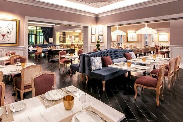 Innenansicht des Restaurants im Lopesan Costa Bavaro Resort Spa & Casino mit gedeckten Tischen und Stühlen.