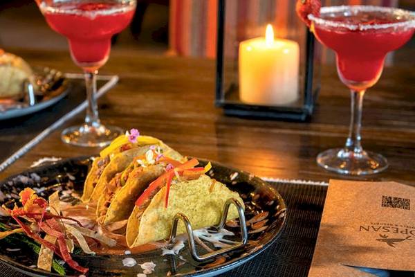 Ein Tisch mit zwei Tellern voller Tacos und Getränken im Lopesan Costa Bavaro Resort Spa & Casino.