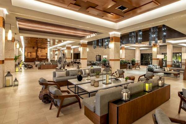 Lobby des Lopesan Costa Bavaro Resorts mit Sofas, Tischen und Lampen.