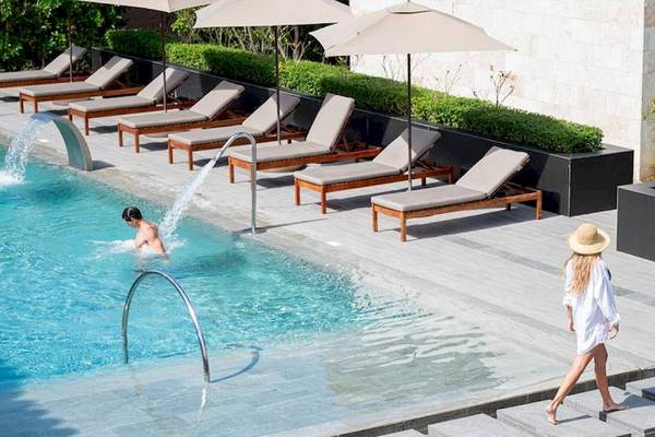 Schwimmbad im Lopesan Costa Bavaro Resort Spa & Casino mit Sonnenliegen, Sonnenschirmen und Gästen