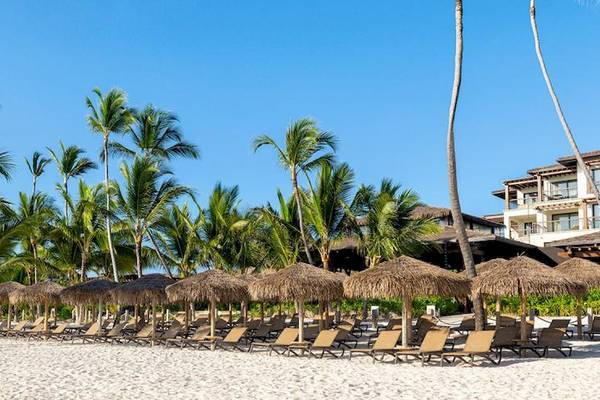Strand des Lopesan Costa Bavaro Resort mit Sonnenliegen und Palmen