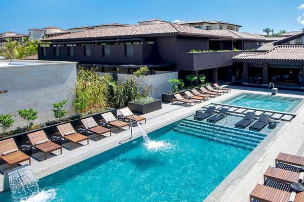 Außenpoolbereich des Lopesan Costa Bavaro Resort Spa & Casino mit Sonnenliegen und Wasserfall