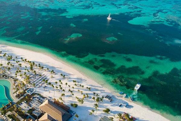 Luftaufnahme des Lopesan Costa Bavaro Resorts mit einem großen Pool, weißen Stränden und mehreren Booten im Wasser.