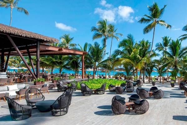 Außenbereich des Lopesan Costa Bavaro Resort Spa & Casino mit Palmen und Strand