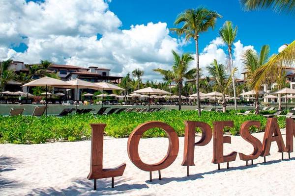 Strand des Lopesan Costa Bavaro Resorts mit Palmen und Loungestühlen