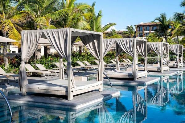 Pool-Loungebereich mit Sonnenbetten und Markisen im Lopesan Costa Bavaro Resort