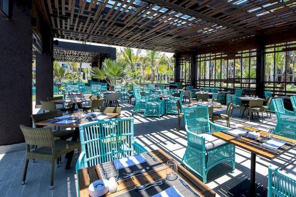 Außenrestaurant des Lopesan Costa Bavaro Resort Spa & Casino mit blauen Stühlen und Tischen.