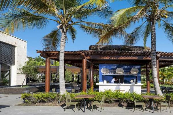 Außenbereich des Lopesan Costa Bavaro Resort Spa & Casino mit Bar und Palmen