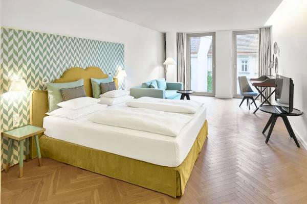 Schlafzimmer im MAXX by Steigenberger Vienna mit grüner Wandverkleidung und zwei Betten