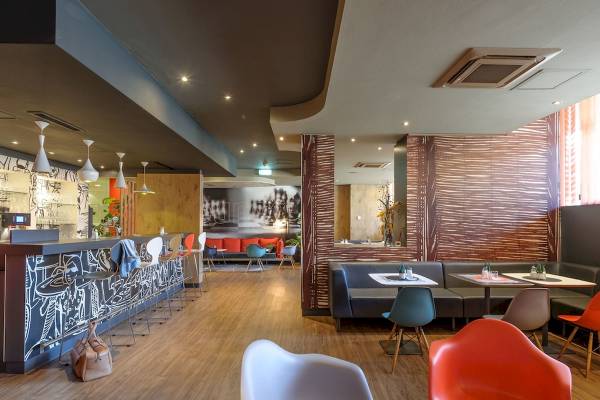 Innenbereich des Ibis Wien Mariahilf Hotels mit modernen Möbeln und Holzboden.