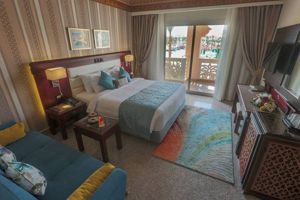 Hotelzimmer im Pickalbatros Palace Resort, Hurghada mit großem Bett, Sofa und Balkon.