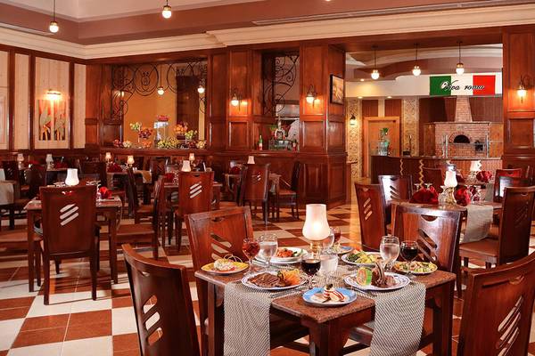 Innenbereich des Restaurants im Pickalbatros Palace Resort, Hurghada, mit gedeckten Tischen und Holzmöbeln.