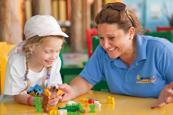 Frau im blauen Poloshirt spielt mit einem kleinen Mädchen im Siva Grand Beach Hotel.