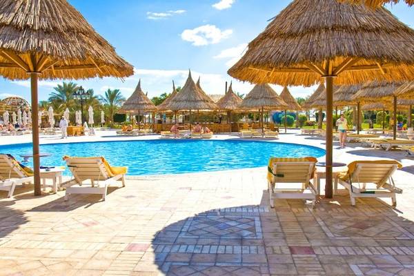 Poolbereich des Siva Grand Beach Hotel mit Sonnenschirmen und Liegestühlen.