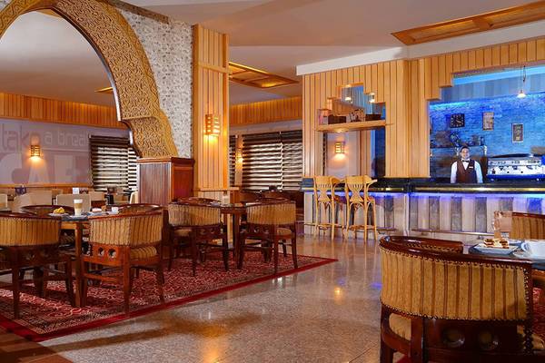 Innenansicht des Restaurants im Pickalbatros Palace Resort in Hurghada mit Tischen, Stühlen und einer Bar.