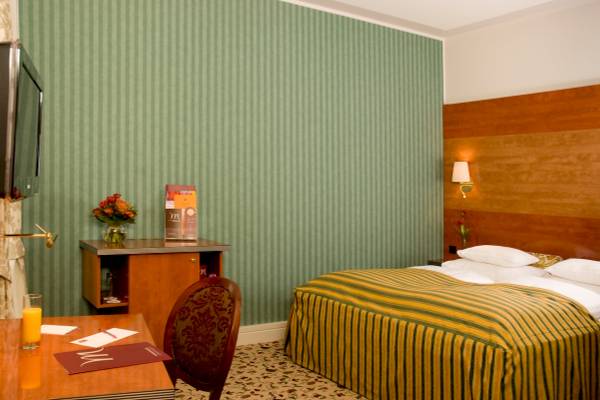 Doppelbettzimmer im Mercure Grand Hotel Biedermeier mit grünen Wänden und einem Schreibtisch