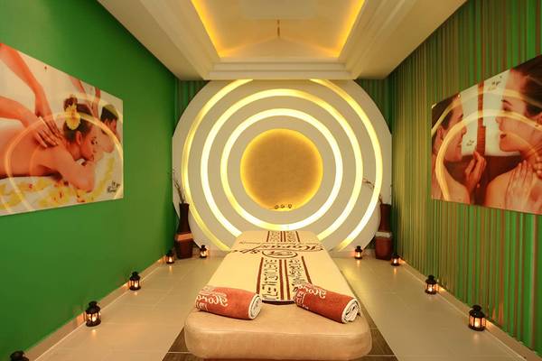 Spa-Behandlungsraum im Pickalbatros Palace Resort, Hurghada mit grünen Wänden, zwei großen Bildern und einer zentralen Lampe.
