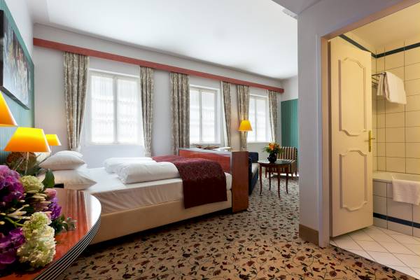 Hotelzimmer im Mercure Grand Hotel Biedermeier mit Bett, Blumen, Tisch und Badezimmer