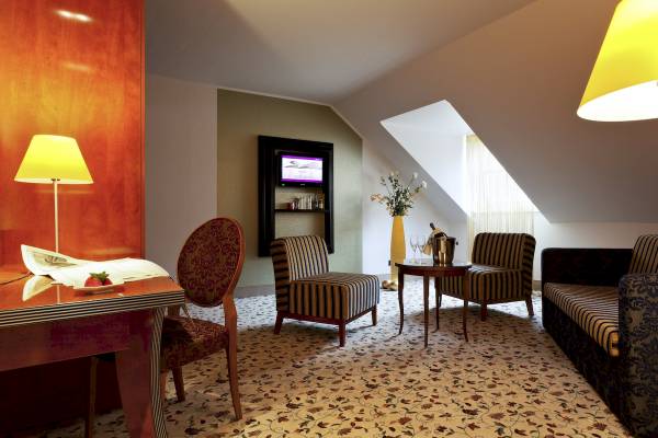 Suite im Mercure Grand Hotel Biedermeier mit Wohnzimmer, Esstisch, Fernseher und Balkon