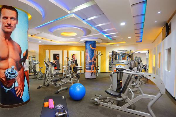 Fitnessstudio im Hotel Pickalbatros Palace Resort mit diversen Geräten und großen Wandpostern.