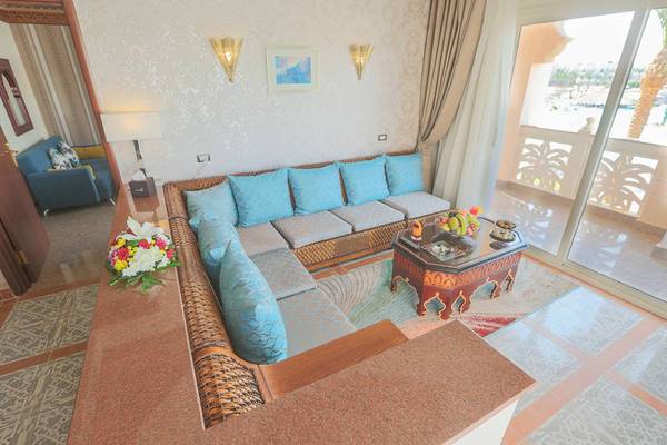 Wohnzimmer im Pickalbatros Palace Resort in Hurghada mit einem großen Sofa, Tisch und einem Blick auf den Pool.