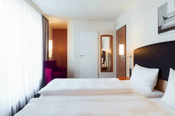 Schlafzimmer im IntercityHotel Wien mit zwei Betten, Dekor und Möbeln