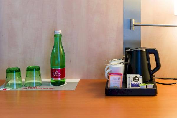 Tisch im IntercityHotel Wien Zimmer mit Wasserflasche, Tassen, Kaffeekanne und Teebeuteln