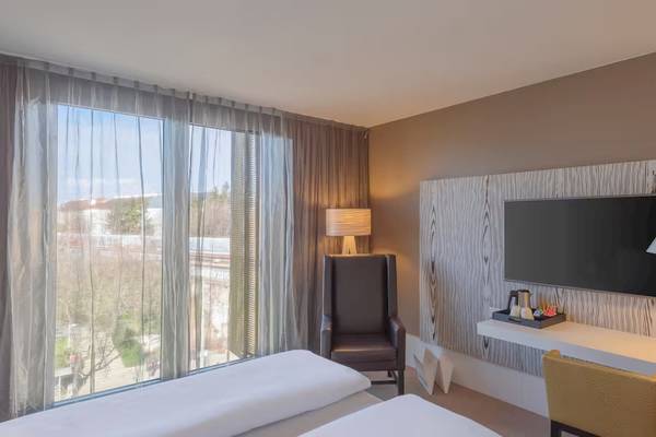 Doppelzimmer im DoubleTree by Hilton Vienna Schonbrunn mit Blick auf die Stadt.