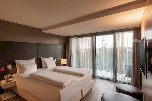 Doppelzimmer im DoubleTree by Hilton Vienna Schonbrunn mit zwei Betten, Fenstern und Balkon
